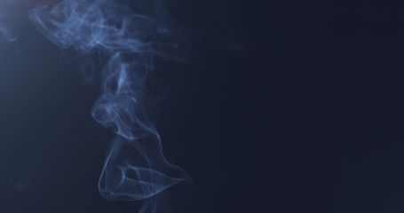 mystery blue smoke over dark background with copy space