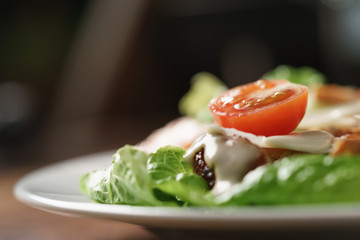 caesar salad with cherry tomatoes on wooden table