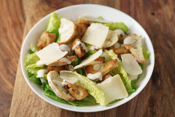 shot of caesar salad with chicken in white bowl