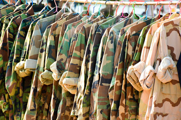 Many military shirt hang on a wood clothesline 