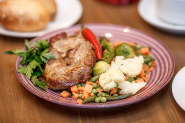 Grilled steak with vegetables and herbs on plate