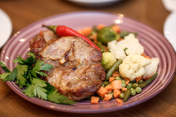 Grilled steak with vegetables and herbs on plate