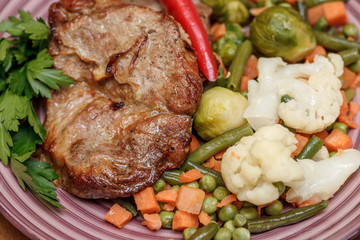 Grilled steak with vegetables and herbs on plate