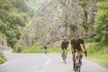 Three road cyclists attacking the climb in Cheddar Gorge