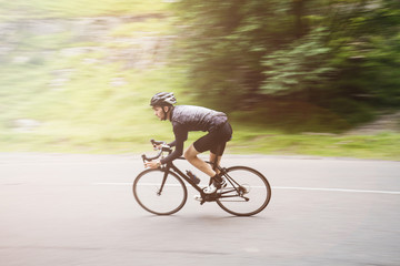 Fototapeta premium Panning shot of a young road cyclist flying round a corner in Ch