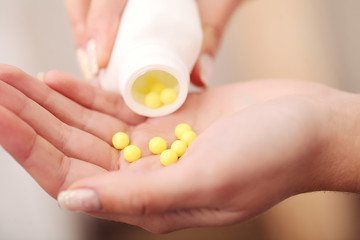 Closeup of woman's hands holding medicine pills