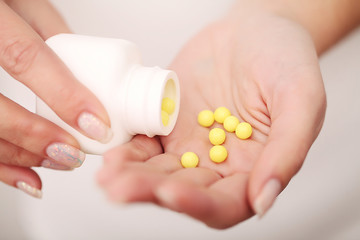 Closeup of woman's hands holding medicine pills