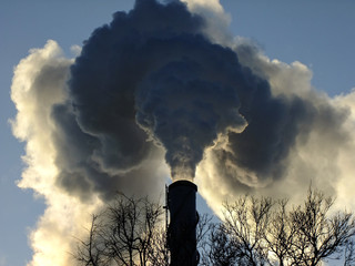 High Chimney emits Smoke during Sunset