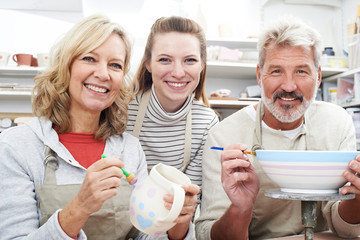 Mature Couple With Teacher In Pottery Class