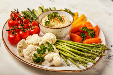 Healthy homemade hummus with assorted fresh vegetables.