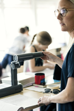 Teacher using camera for reading book at classroom