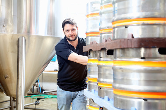 Worker in brewery organising beer barrels for delivery