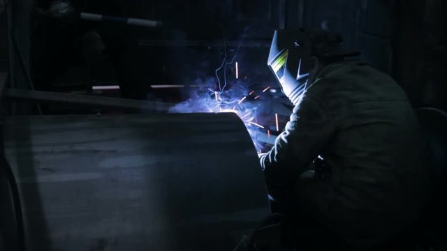 Workers grinding and welding in a factory