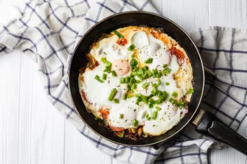 Foto auf Acrylglas Spiegeleier Breakfast on the table: a fried egg in frying pan