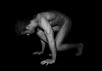 Nude muscular man crouching