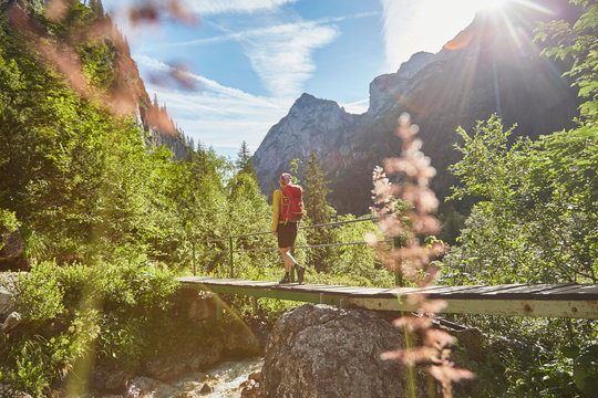 Woman walking across bridge, H&iacute;_llental, Zugspitze, Garmisch-Partenkirchen, Bavaria, Germany
