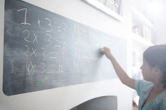 Girl doing maths on blackboard