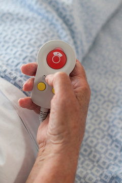 Cropped view of patient's hand holding call button