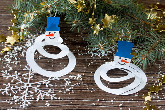 The child makes a toy on the Christmas tree snowman paper. Glue,