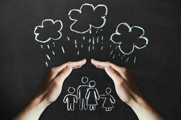 hands protects a family from the elements - rain or storm