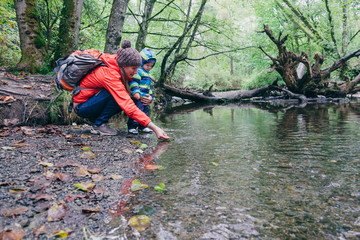 Mother and son exploring stream in forest, Vancouver, British Columbia, Canada