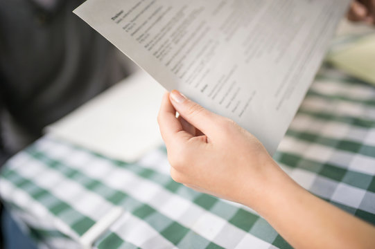 Cropped view of woman's hands holding menu