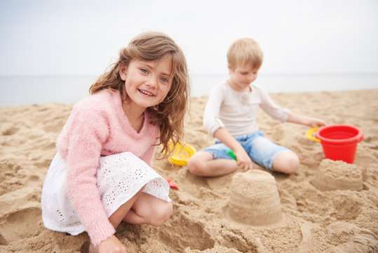 Children building sand castle on beach