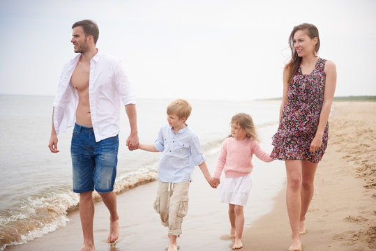 Family holding hands walking on beach