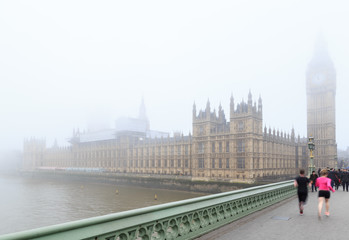 Joggers running over Westminster Bridge, near Big Ben, London.