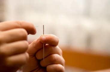 the child's hands, put thread in a needle