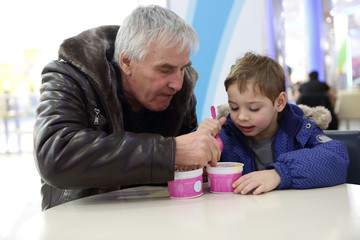 Naklejka premium Grandfather and grandson have ice cream