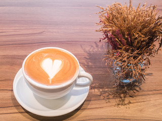 Hot coffee in white cup on wooden table