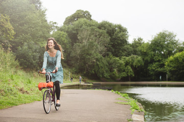 Young lady out in the park at dusk with her vintage bicycle