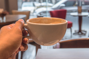 Hot coffee in white cup in hand