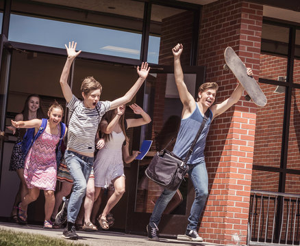 Male And Female High School Students Running Out Of High School