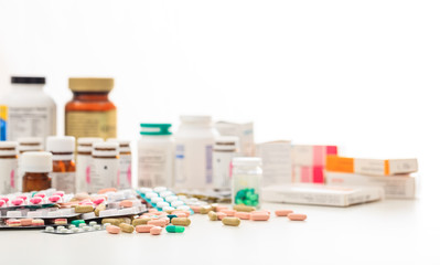 Stack of pills and containers on white background