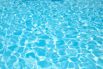 Naklejka na ściany i meble Blue water surface with sun reflection in swimming pool