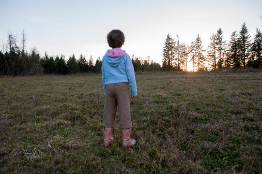 Rear view of girl looking at view of sunset, Centralia, Washington, USA