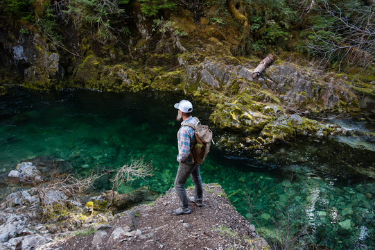 Man standing on rock looking away at river, Opal Creek, Oregon, USA