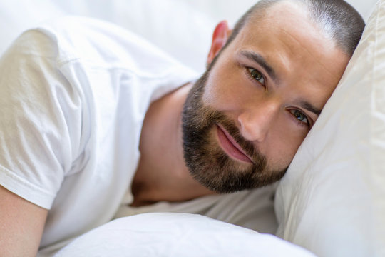 Portrait of mid adult man lying in bed