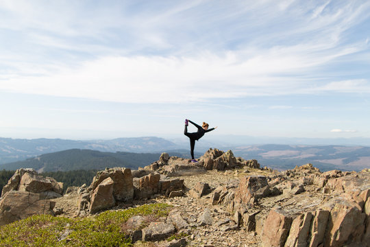 Young woman standing on rock, in yoga position, Silver Star Mountain, Washington, USA
