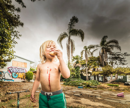 Boy eating treat with jam dripping down chest