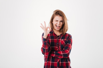 Happy young woman showing ok sign with fingers an winking