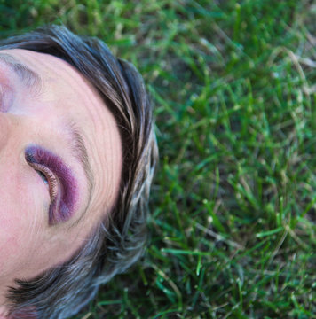 Cropped view of man with black eye lying on grass