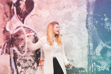 Obraz premium Young beautiful caucasian blonde woman listening music with earphones and smart phone hand hold, dancing - happiness, serene, freedom concept - colorful filtered