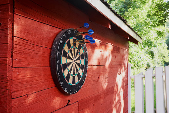 Dartboard hanging on shed, darts in board