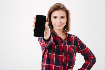 Naklejka premium Confident young woman showing blank smartphone screen
