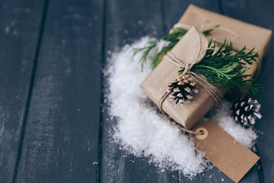Wrapped Christmas gifts with pine cone, fir and fake snow decoration - Powered by Adobe