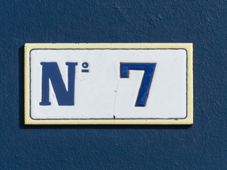 Street sign reading the number seven.