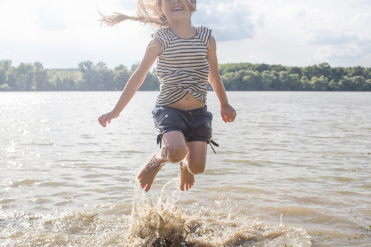 Girl jumping and splashing in river